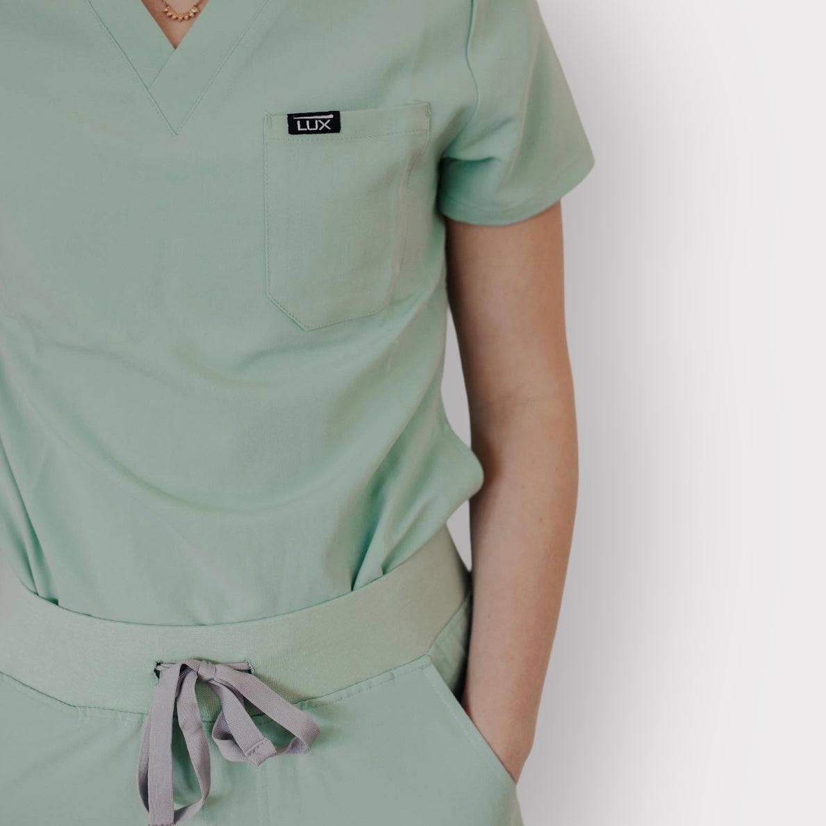 Lux Scrubs Sage Green Scrub Top. One chest pocket. 2 lower front pockets