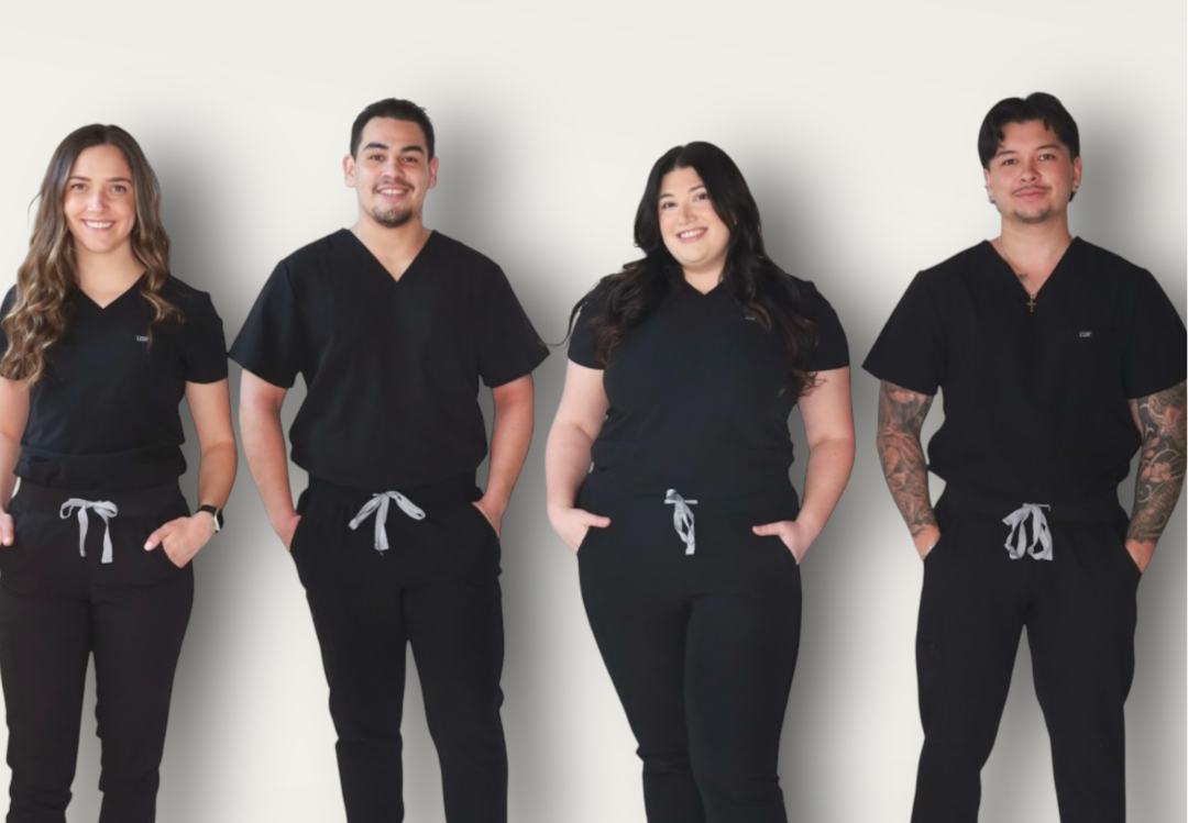 Four individuals wearing black scrubs against a white background